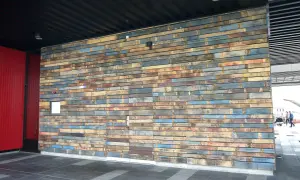 Un mur en palette extérieure aux couleurs vives et variées, créant une texture unique.
